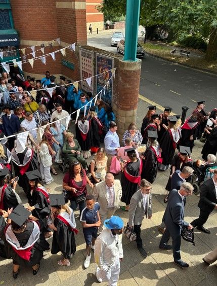 Students wearing graduation caps walking 