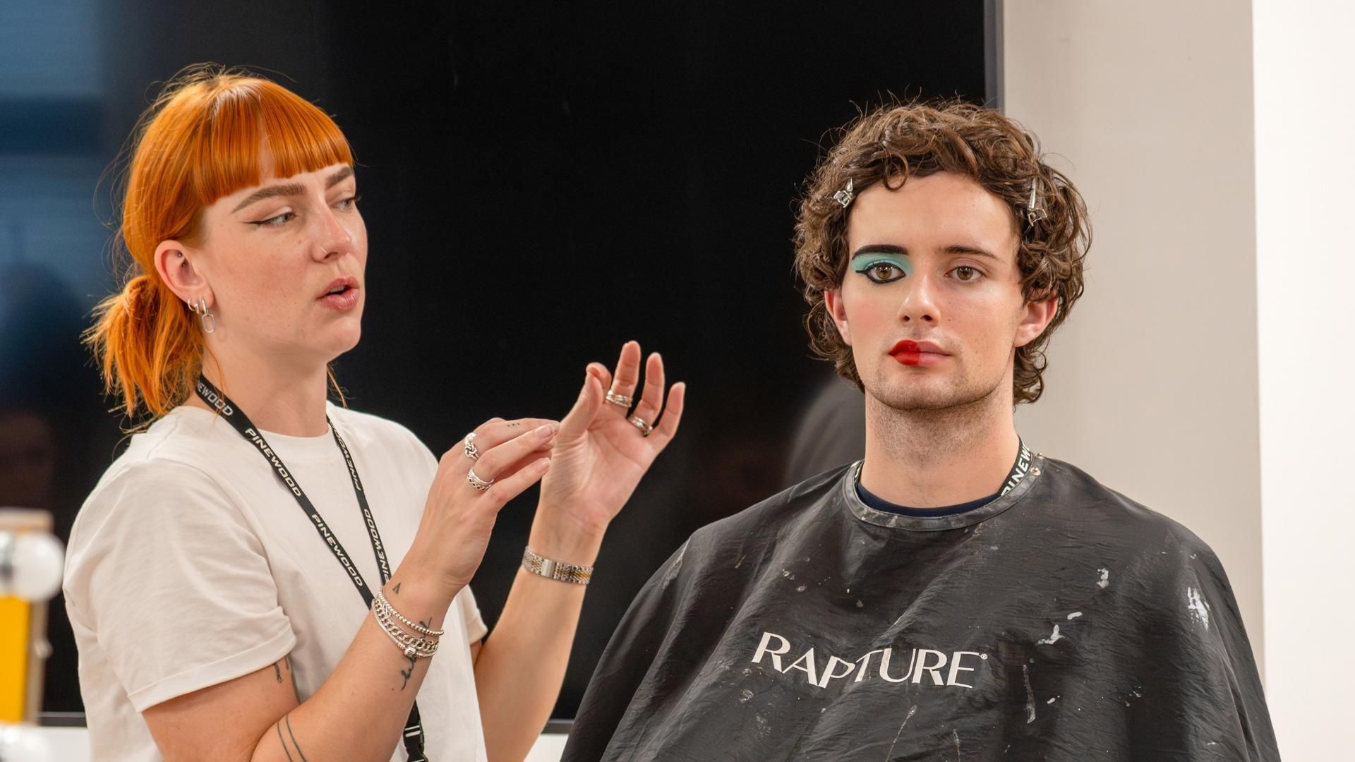 A hair and make-up lecturer uses a student to test their SFX skills on.