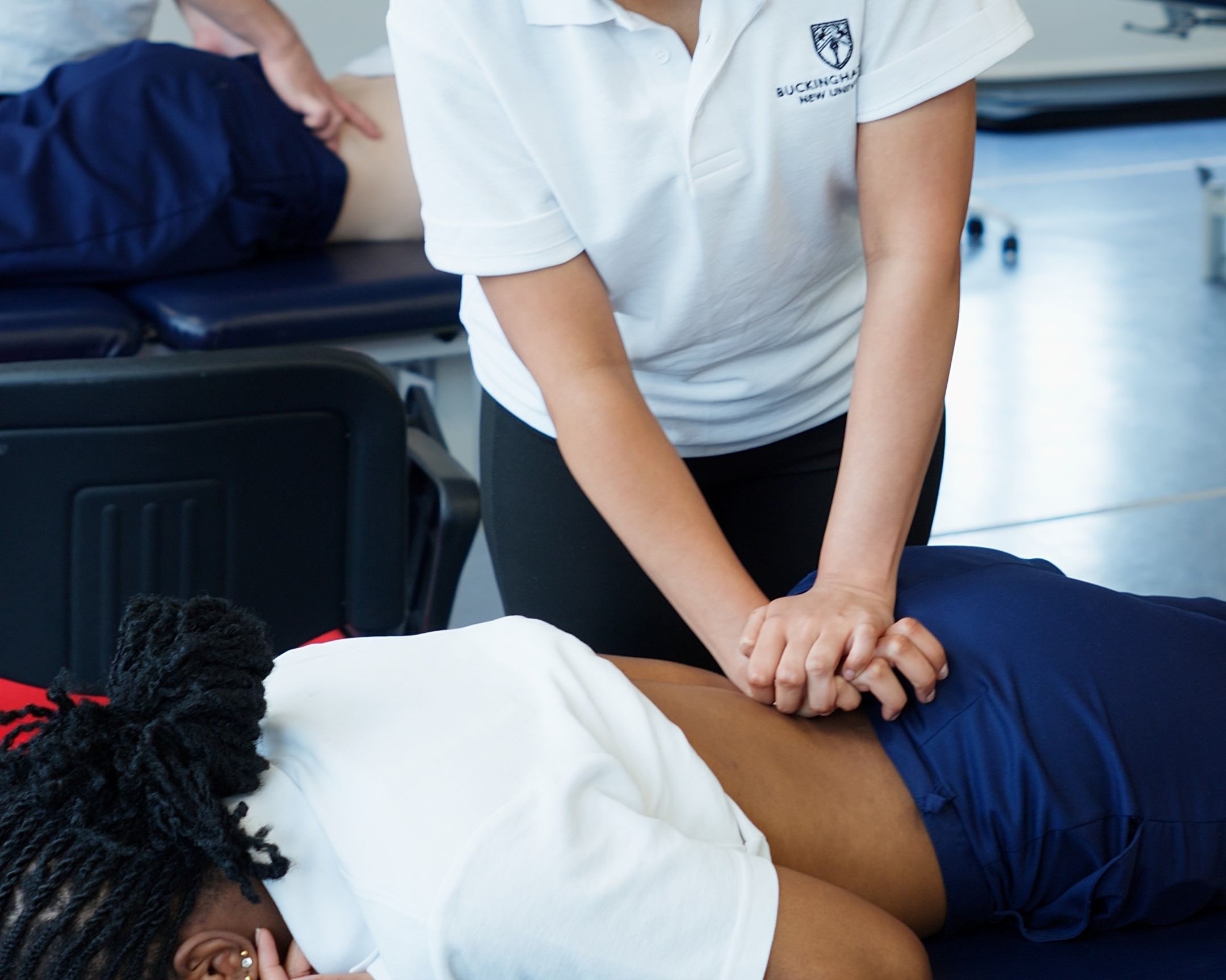 Physiotherapy student practicing manual therapy techniques on a colleague during a practical session